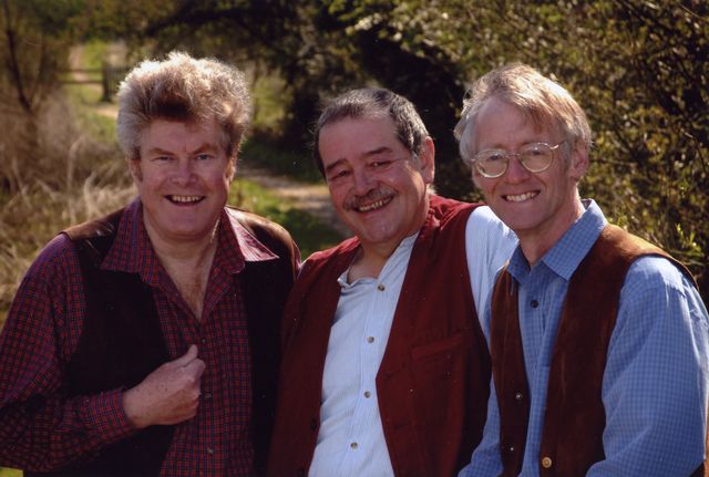 The three standing together, smiling, on a country path